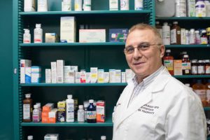 Pharmacist Standing In Front Of Prescriptions